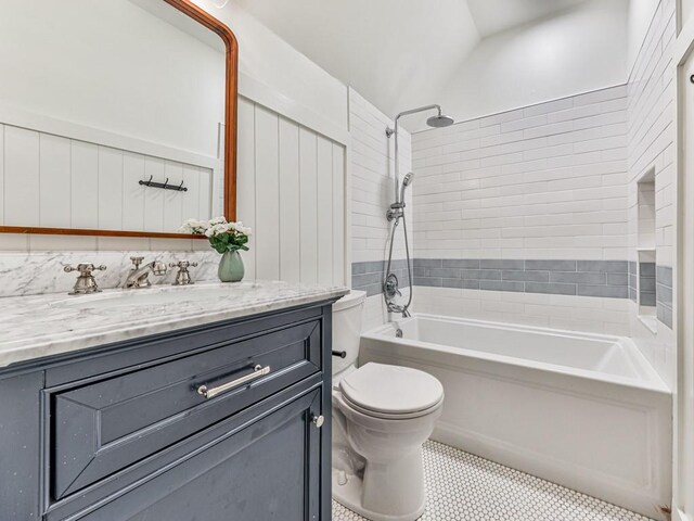 full bathroom featuring vanity, lofted ceiling, tile patterned flooring, tiled shower / bath combo, and toilet