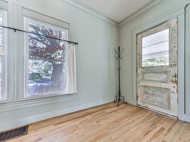 interior space with crown molding, a healthy amount of sunlight, and light wood-type flooring