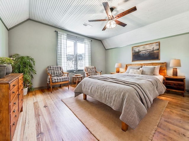 bedroom with ceiling fan, light hardwood / wood-style flooring, and vaulted ceiling