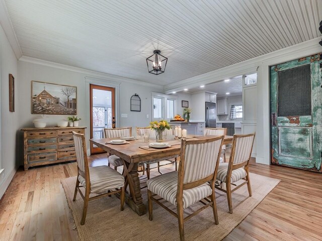 dining room featuring a chandelier, light hardwood / wood-style floors, and ornamental molding