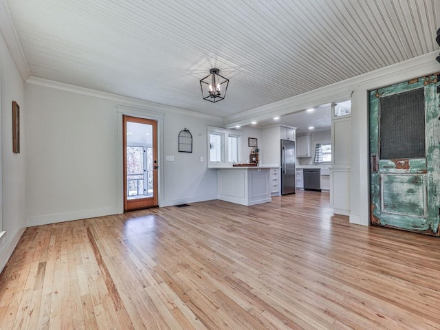 unfurnished living room with a chandelier, crown molding, and light hardwood / wood-style flooring