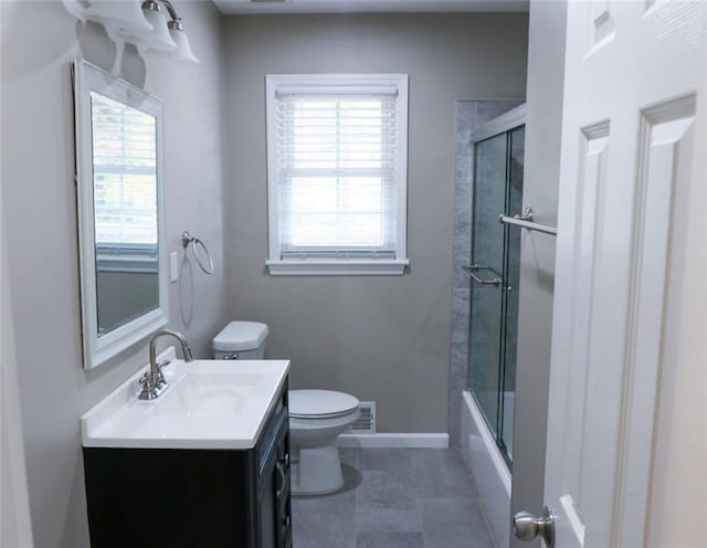 full bathroom with vanity, toilet, a wealth of natural light, and bath / shower combo with glass door