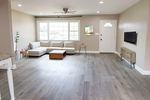 living room featuring light hardwood / wood-style floors and ceiling fan