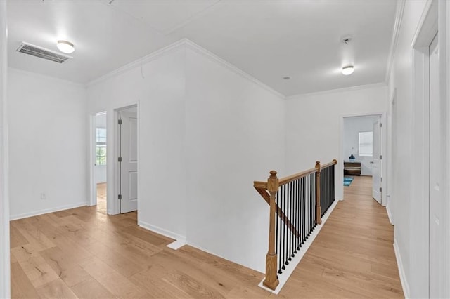 hallway featuring ornamental molding, an upstairs landing, visible vents, and light wood-style floors