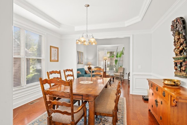 dining room featuring a tray ceiling, a wealth of natural light, and light wood-type flooring