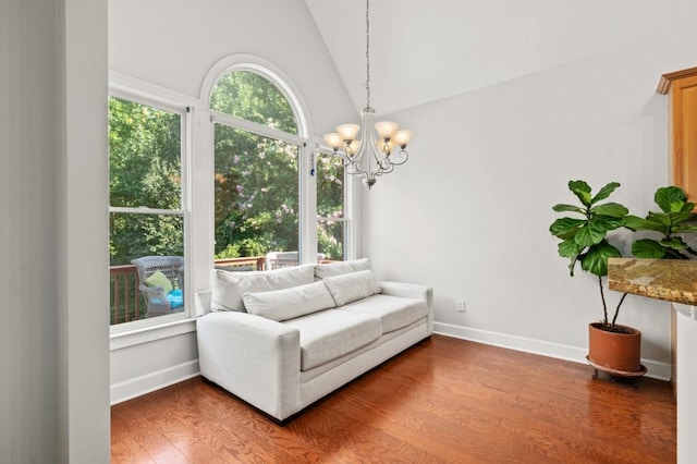 sitting room featuring wood-type flooring, lofted ceiling, and a notable chandelier