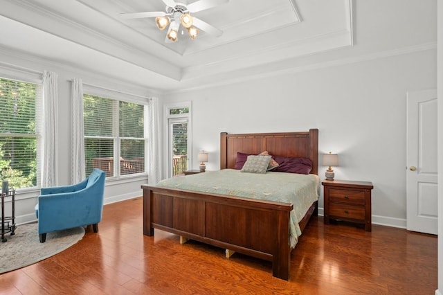 bedroom featuring multiple windows, a raised ceiling, ceiling fan, and ornamental molding