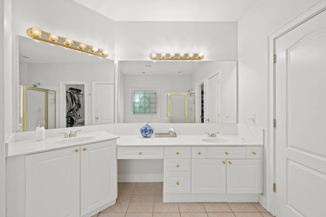 bathroom featuring tile patterned flooring, vanity, and a shower with shower door