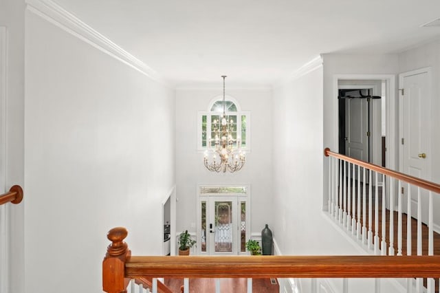 foyer with an inviting chandelier and ornamental molding