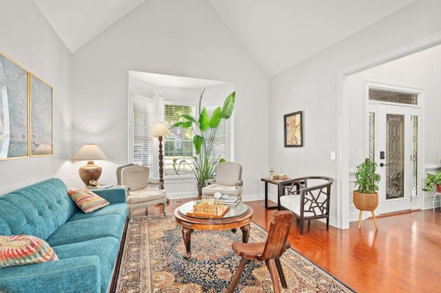 living room with hardwood / wood-style floors and high vaulted ceiling