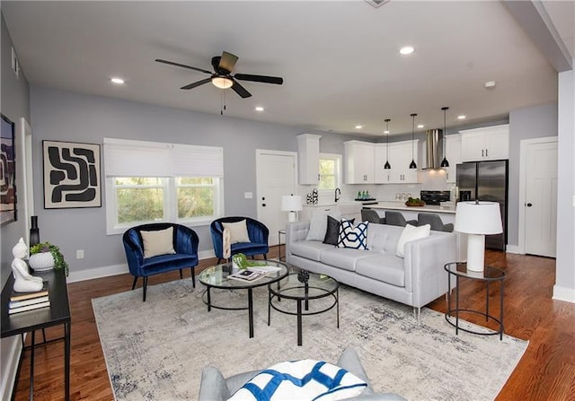 living room with ceiling fan and dark hardwood / wood-style flooring