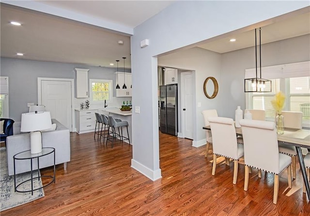 dining area with dark hardwood / wood-style flooring and a notable chandelier