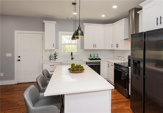 kitchen featuring white cabinetry, sink, black appliances, and a center island