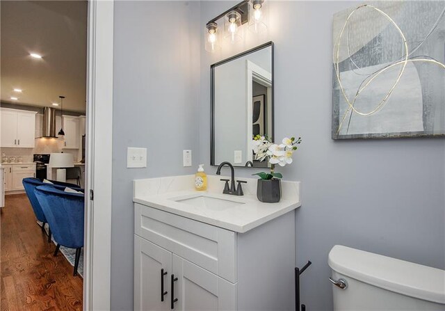 bathroom featuring vanity, hardwood / wood-style floors, and toilet