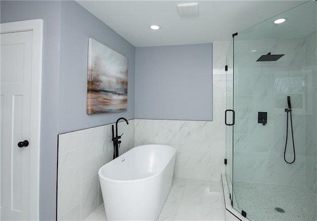 bathroom with separate shower and tub and tile walls