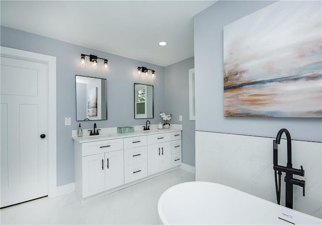 bathroom featuring vanity and a washtub