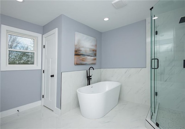 bathroom featuring separate shower and tub and tile walls