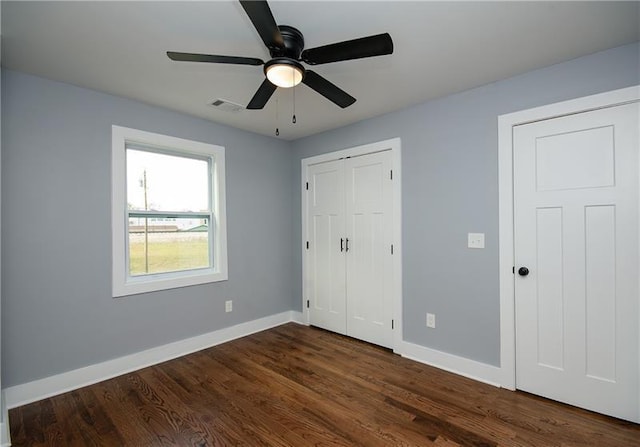 unfurnished bedroom with dark wood-type flooring, ceiling fan, and a closet