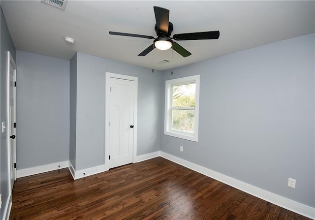 unfurnished bedroom featuring dark hardwood / wood-style floors, ceiling fan, and a closet