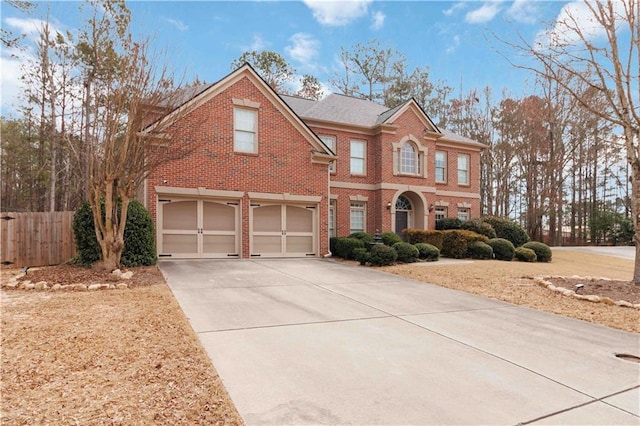 view of front of property with an attached garage, driveway, fence, and brick siding