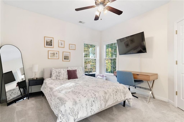 bedroom with a ceiling fan, light colored carpet, visible vents, and baseboards