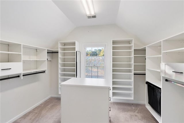 walk in closet with lofted ceiling, light carpet, and visible vents