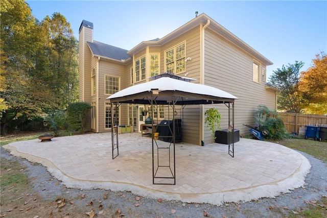 back of property featuring a patio area, fence, and a gazebo