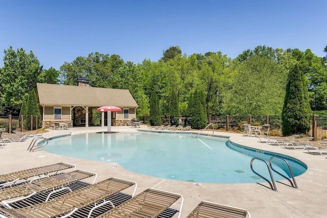 community pool featuring fence and a patio