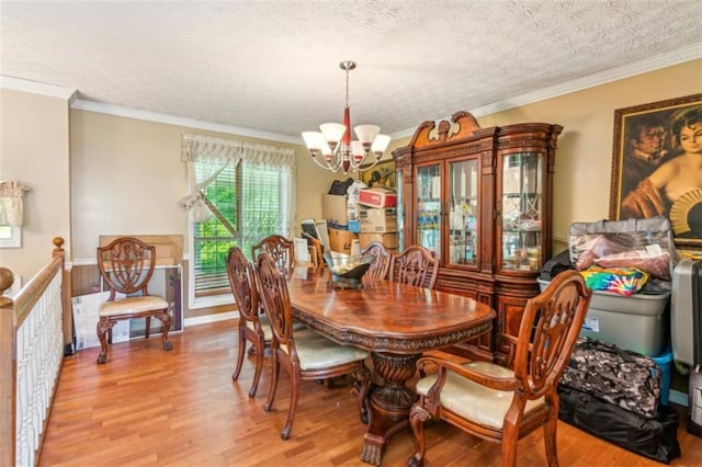 60 Boardwalk Ave, Covington, GA 30016 - dining space with a chandelier, light wood-type flooring, crown molding, and a textured ceiling
