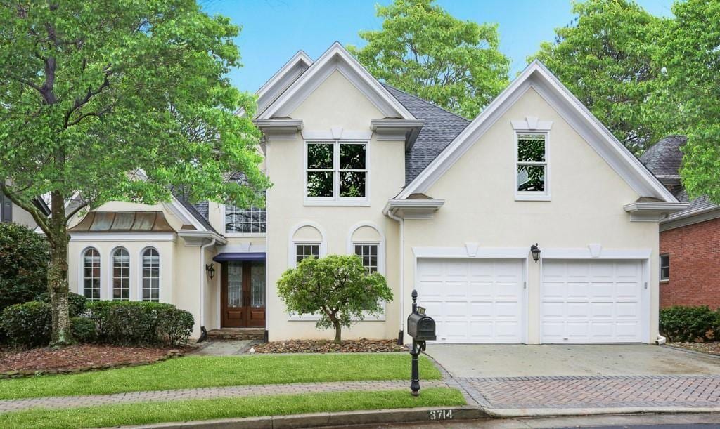 3714 Westbrooke Cir NE, Brookhaven, GA 30319 - view of front facade featuring stucco siding, driveway, and french doors