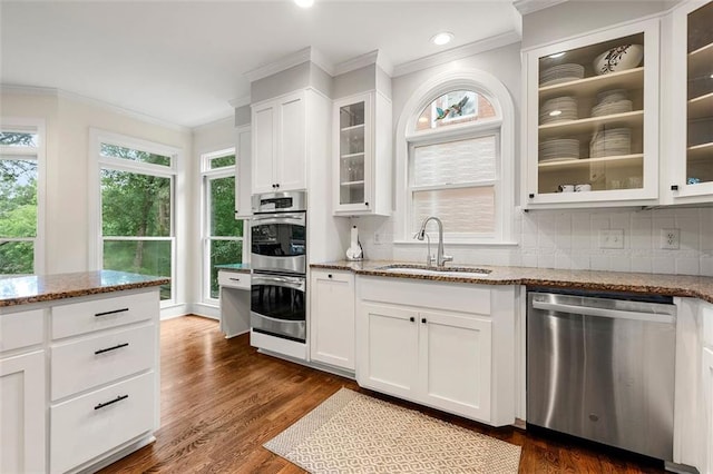 3714 Westbrooke Cir NE, Brookhaven, GA 30319 - kitchen featuring stainless steel appliances, a sink, crown molding, light stone countertops, and backsplash