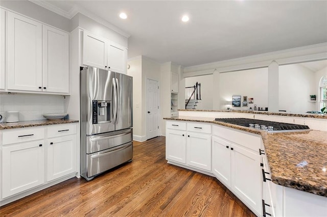 3714 Westbrooke Cir NE, Brookhaven, GA 30319 - kitchen with appliances with stainless steel finishes, crown molding, wood finished floors, white cabinets, and dark stone counters