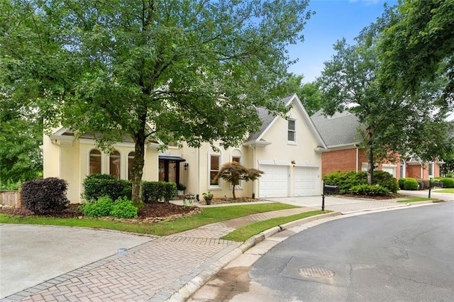 3714 Westbrooke Cir NE, Brookhaven, GA 30319 - view of property hidden behind natural elements featuring driveway, stucco siding, and a garage