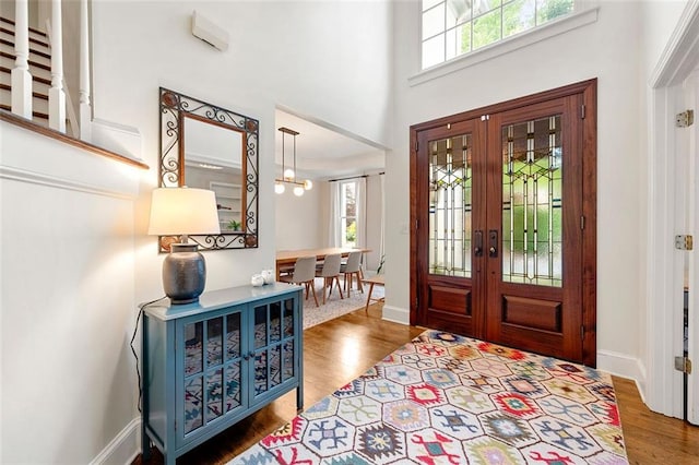 3714 Westbrooke Cir NE, Brookhaven, GA 30319 - foyer featuring french doors, wood finished floors, baseboards, a high ceiling, and a chandelier