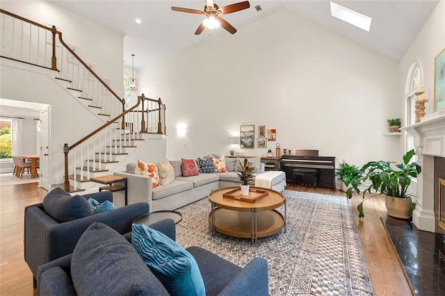 3714 Westbrooke Cir NE, Brookhaven, GA 30319 - living area featuring high vaulted ceiling, stairway, wood finished floors, a ceiling fan, and a fireplace