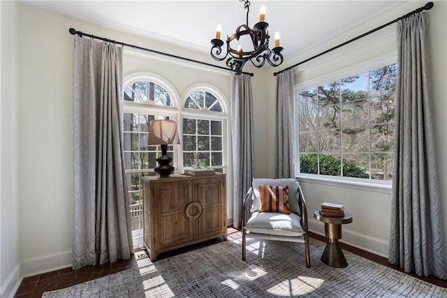 living area with a chandelier, a wealth of natural light, and baseboards