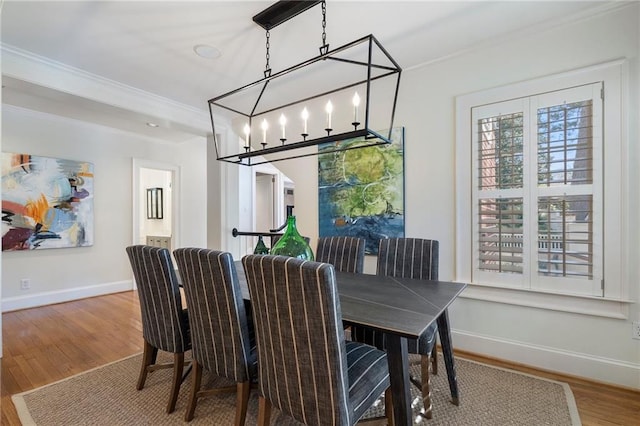 dining area featuring ornamental molding, baseboards, and wood finished floors