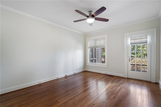 unfurnished room with ornamental molding, a healthy amount of sunlight, baseboards, and wood finished floors