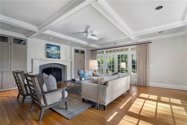 living area featuring a fireplace, light wood finished floors, coffered ceiling, beamed ceiling, and baseboards