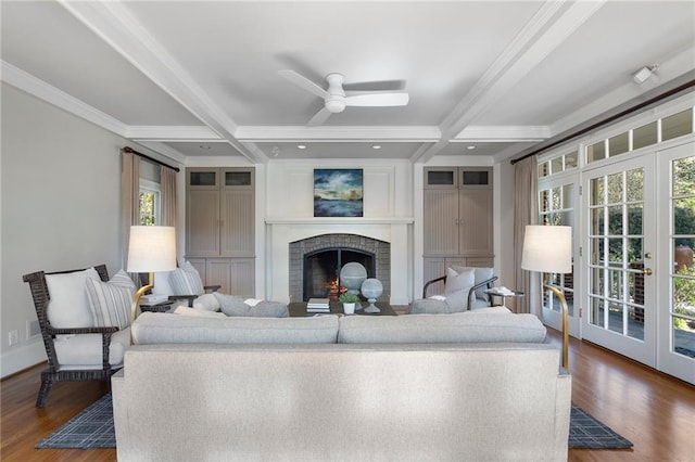 living room featuring french doors, a fireplace, beam ceiling, and wood finished floors