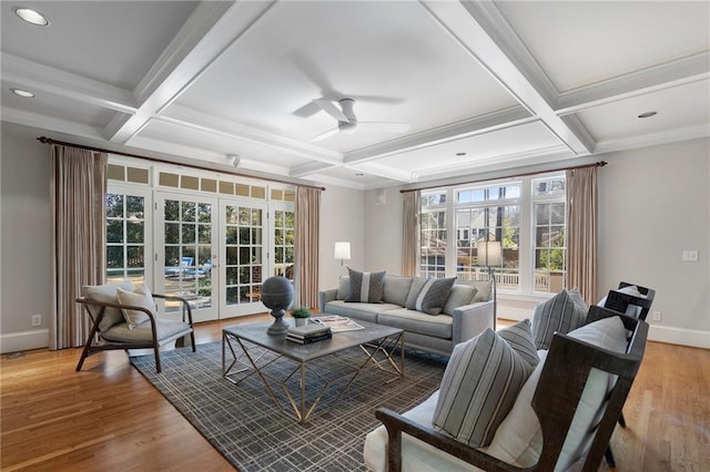 living area featuring french doors, light wood-type flooring, coffered ceiling, and baseboards