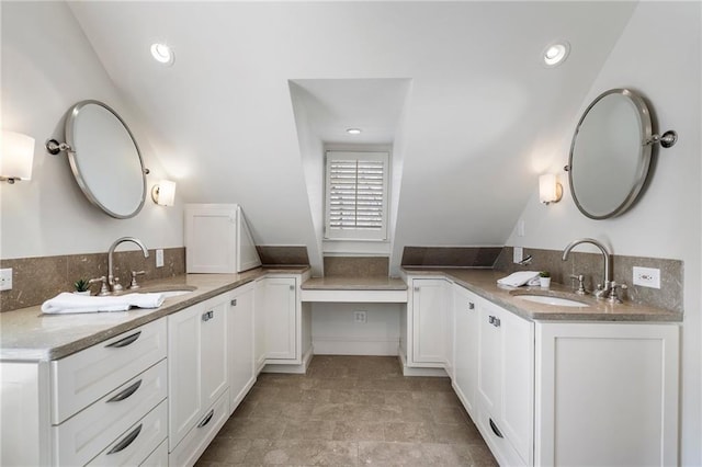 bathroom with recessed lighting, two vanities, and a sink