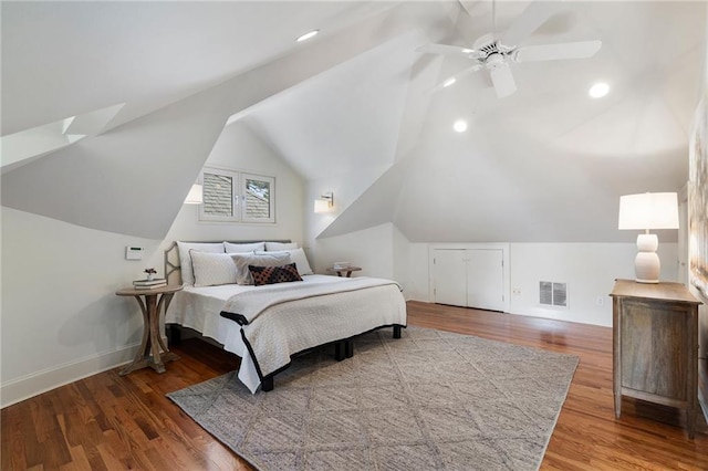 bedroom with a ceiling fan, visible vents, vaulted ceiling, and wood finished floors