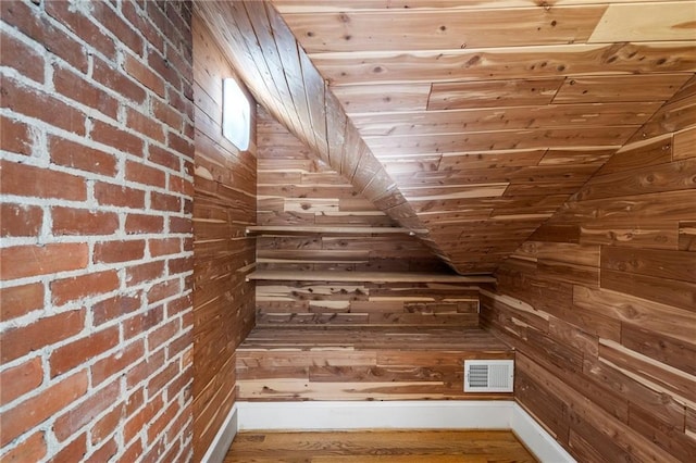 staircase featuring wooden ceiling, visible vents, and wood walls