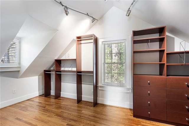 bonus room with baseboards, vaulted ceiling, and wood finished floors