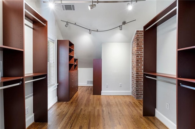 walk in closet with visible vents and wood finished floors