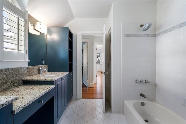 bathroom with tile patterned flooring, vaulted ceiling, tub / shower combination, and vanity