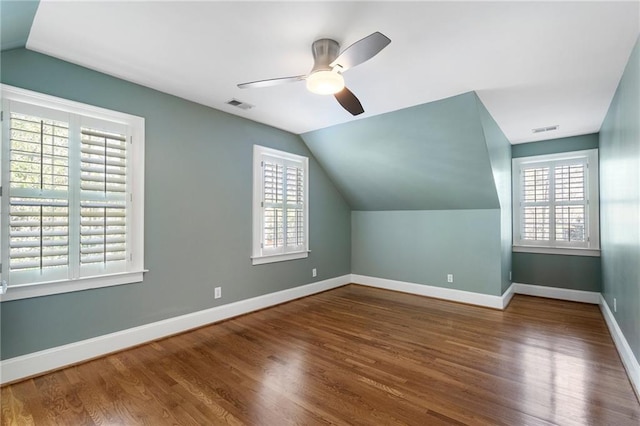 bonus room with lofted ceiling, baseboards, visible vents, and wood finished floors