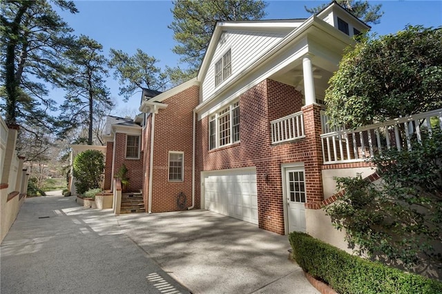 view of home's exterior featuring concrete driveway, brick siding, and an attached garage