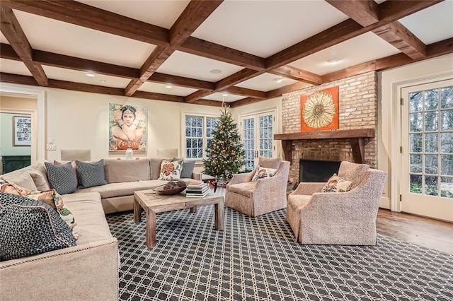 living room featuring beam ceiling, wood-type flooring, a fireplace, and coffered ceiling